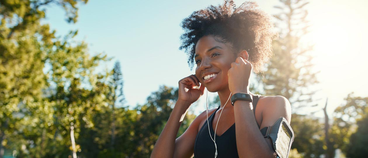 Young woman listening to music while jogging