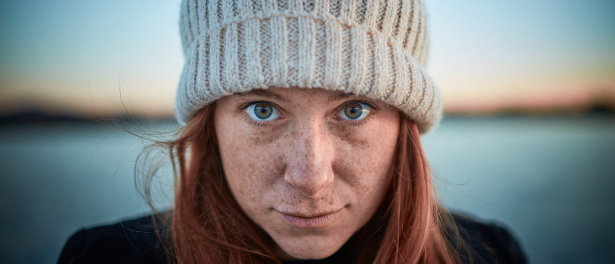 Close up of woman's face with water in the background