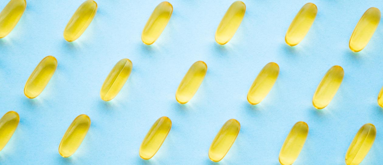 Flat-lay of fish oil capsules on a blue background