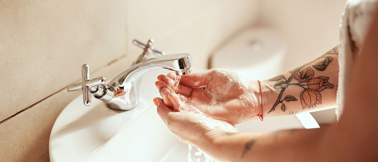 Young woman washing her hands with soap and water