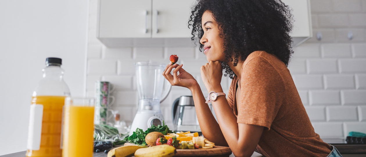 young woman making a healthy snack with fruit at home