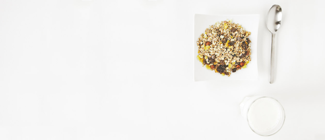 Flat lay of granola on a white plate on a white background